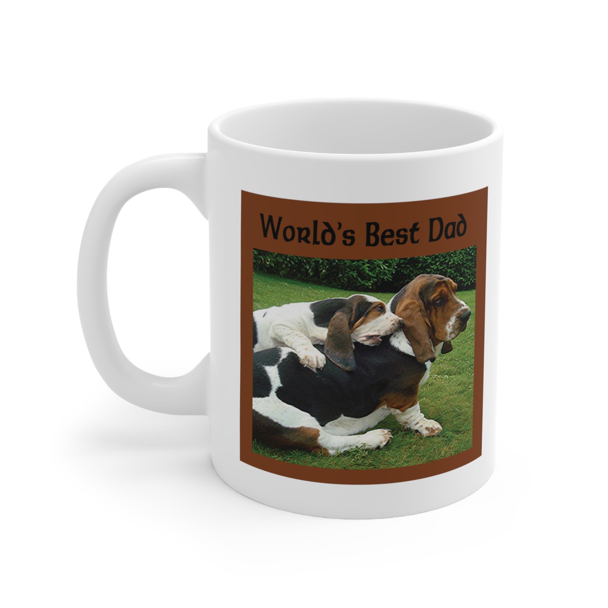 A white ceramic coffee mug with a photo design of a Basset dog being hugged by his puppy. The greeting at the top reads: World's best dad.