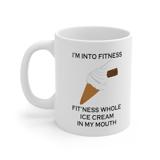 A white ceramic coffee mug with a design of a vanila ice cream and the funny quote: I'm Into fitness, Fit'ness Whole Ice Cream In My Mouth