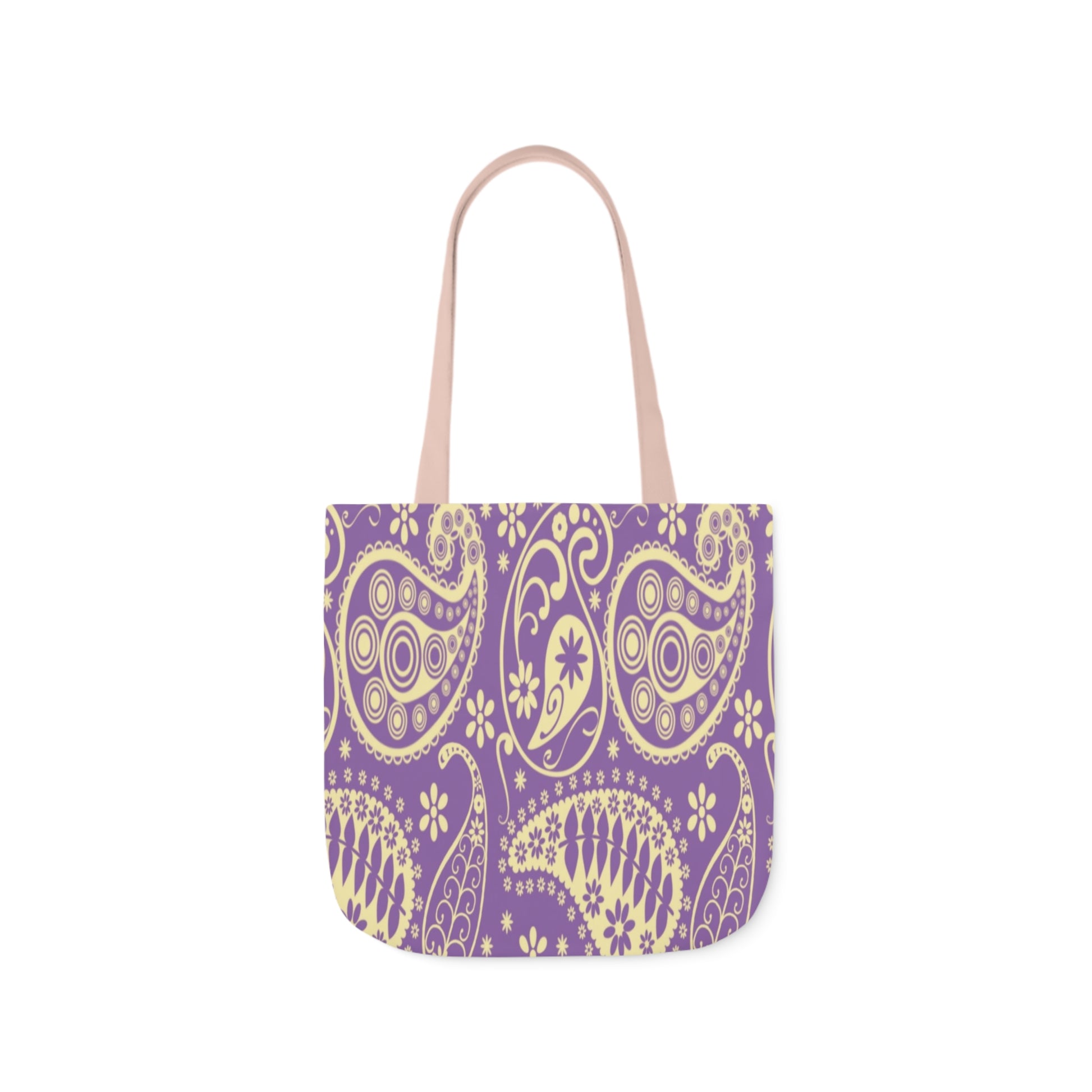 A canvas tote bag with a purple paisley pattern. The tote bag handles are light pink.