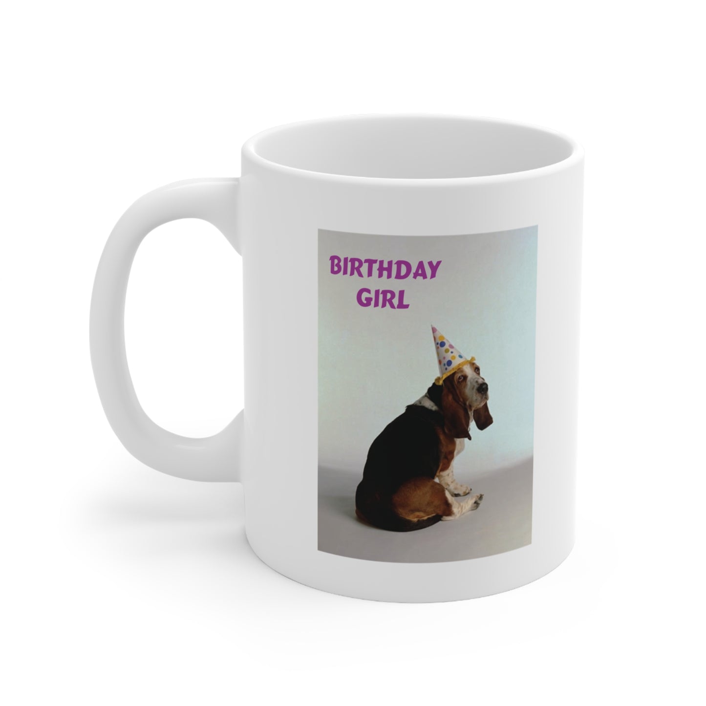 A white ceramic coffee mug with a photo of a Basset hound dog wearing a party hat. The quote reads: Birthday Girl