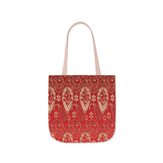 A canvas tote bag with a red paisley pattern. The tote bag has light pink handles