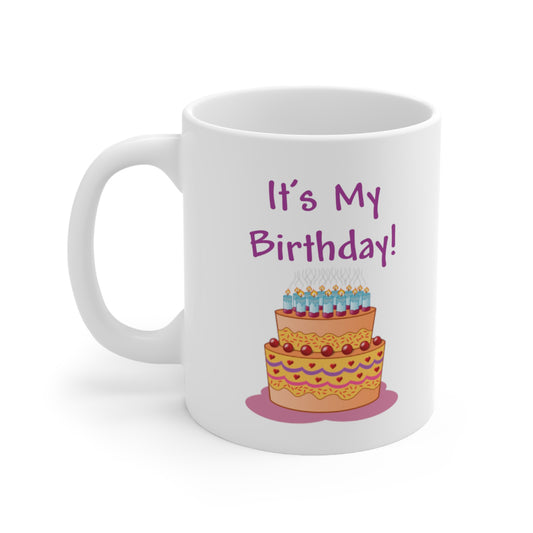 A white ceramic coffee mug with a design of a big birthday cake. The quote reads: It's My Birthday!