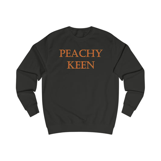 A black sweatshirt with a design of the quote: Peachy Keen, written in peach colour